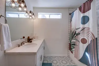 a white bathroom with a sink and a mirror at Urban Spanish Bungalow in San Diego