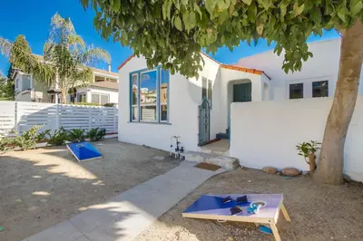 a white house with a table and a tree at Urban Spanish Bungalow in San Diego
