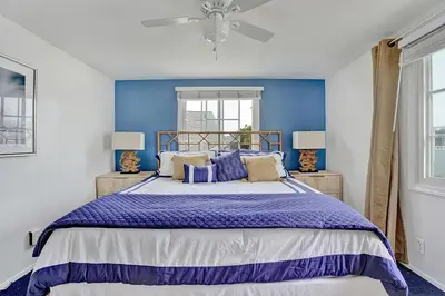 a bedroom with a large bed with a blue wall at 122 Thirty Third Street in Newport Beach
