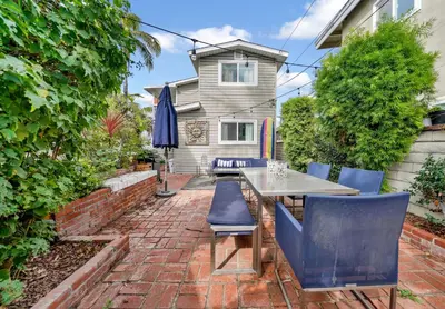 a patio with a table and chairs and an umbrella at 122 Thirty Third Street in Newport Beach