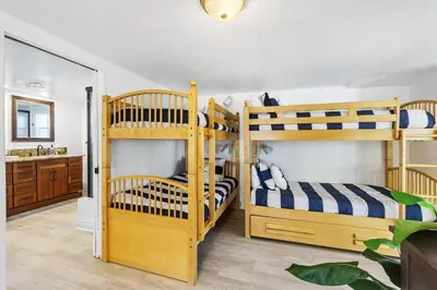 a bedroom with two bunk beds and a bathroom at 122 Thirty Third Street in Newport Beach
