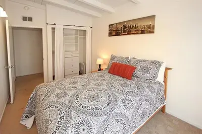 a bedroom with a large bed with a white comforter at 124 Thirty Fourth Street B in Newport Beach