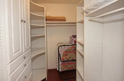 a walk in closet with white cabinets and shelves at 124 Thirty Fourth Street B in Newport Beach