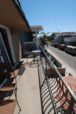 a patio with chairs and a table on a balcony at 124 Thirty Fourth Street B in Newport Beach