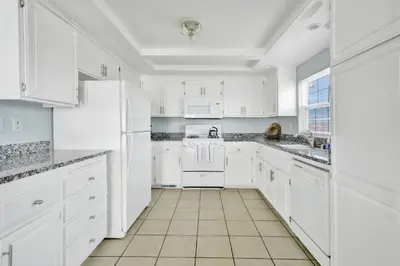 a white kitchen with white cabinets and appliances at 1404 W Oceanfront C in Newport Beach