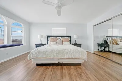 a white bedroom with a bed and two windows at 1404 W Oceanfront C in Newport Beach