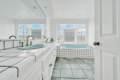 a white bathroom with a tub and a sink at 1404 W Oceanfront C in Newport Beach