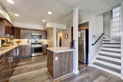 a kitchen with wooden cabinets and a staircase at 2314 W Oceanfront A & B in Newport Beach