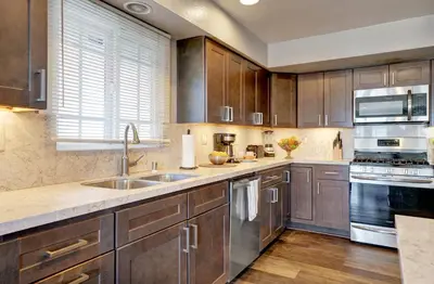 a kitchen with wooden cabinets and stainless steel appliances at 2314 W Oceanfront A & B in Newport Beach