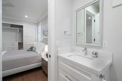 a white bathroom with a sink and a bed at 1225 W Balboa Blvd A & B in Newport Beach
