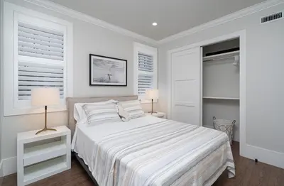 a white bedroom with a bed and two lamps at 1225 W Balboa Blvd A & B in Newport Beach