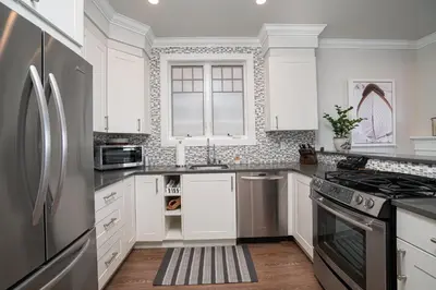 a kitchen with white cabinets and a stainless steel refrigerator at 1225 W Balboa Blvd A & B in Newport Beach