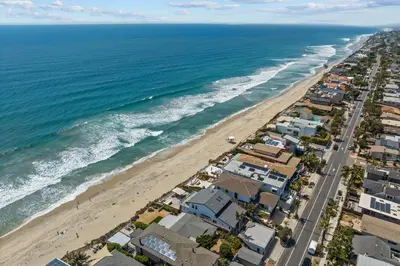an aerial view of a beach with houses and the ocean at Neptune Sunset Shores Oceanfront in Encinitas