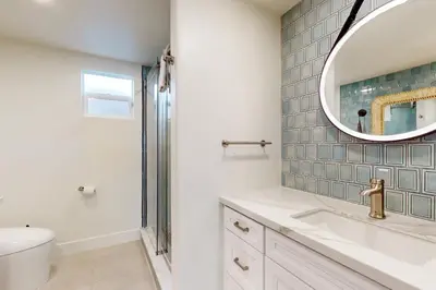 a bathroom with a sink and a mirror at Neptune Sunset Shores Oceanfront in Encinitas