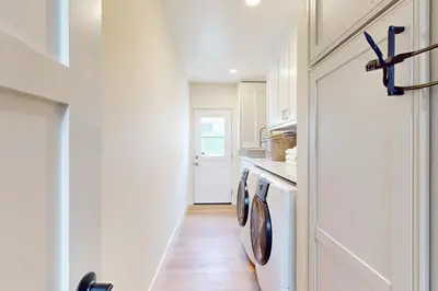 a kitchen with two washing machines in a hallway at Neptune Sunset Shores Oceanfront in Encinitas
