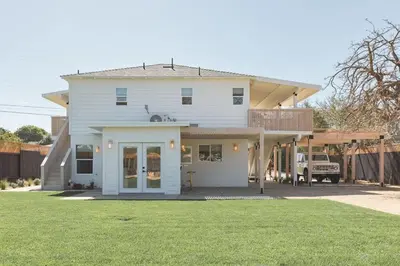 a white house with a porch and a yard at Elegant 2BR with Outdoor Space in Carlsbad