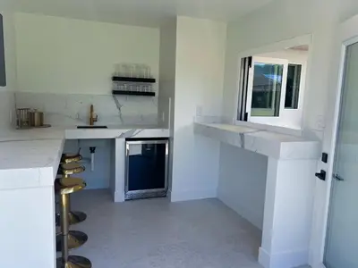 a white kitchen with a counter and a window at Elegant 2BR with Outdoor Space in Carlsbad