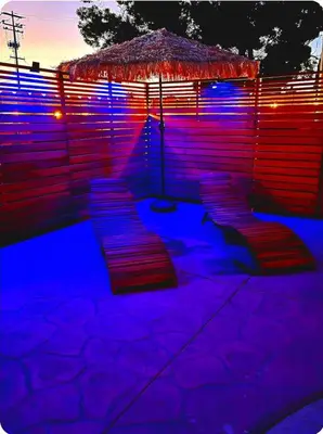 a group of benches under an umbrella at night at 3 BEDS house with pool in National City