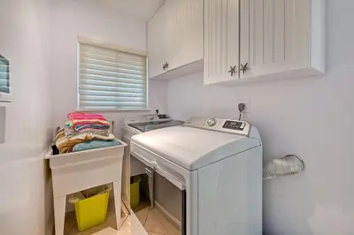 a small kitchen with a sink and a washing machine at Oceanfront Getaway, Private Beach, Fire Pit, 5BR in Oceanside