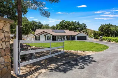 a house with a fence in front of a driveway at Serene Outdoor Oasis Wine Country Home with Views in Glenoak Hills
