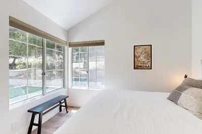 a bedroom with a white bed and large windows at Serene Outdoor Oasis Wine Country Home with Views in Glenoak Hills