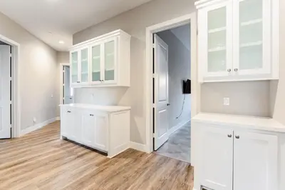 a kitchen with white cabinets and a hardwood floor at Vista Grande home in Ramona