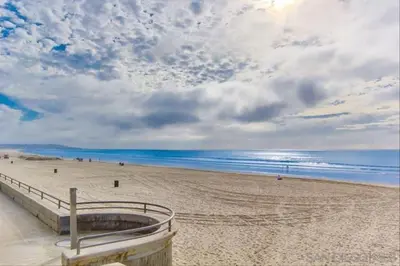 a view of a sandy beach with the ocean at Beach Front Paradise - Entire Condo- Crystal Pier in San Diego