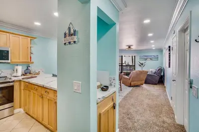 two views of a kitchen and a living room at Beach Front Paradise - Entire Condo- Crystal Pier in San Diego