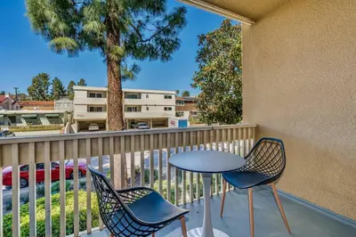 a balcony with a table and chairs and a tree at Pacific Beach Resort Condo - Walk to the Beach in San Diego
