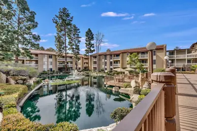 an apartment complex with a pond in the courtyard at Pacific Beach Resort Condo - Walk to the Beach in San Diego