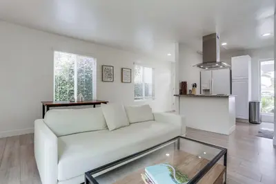 a living room with a white couch and a glass table at A-C 3 Blocks to Ocean Downtown La Jolla Remodel in San Diego