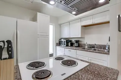 a kitchen with white cabinets and a stove top oven at A-C 3 Blocks to Ocean Downtown La Jolla Remodel in San Diego