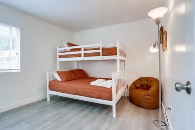 a bedroom with two bunk beds and a chair at A-C 3 Blocks to Ocean Downtown La Jolla Remodel in San Diego