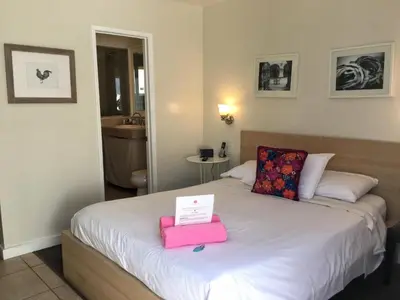 a bedroom with a bed with a pink box on it at El Rancho Motel in San Diego