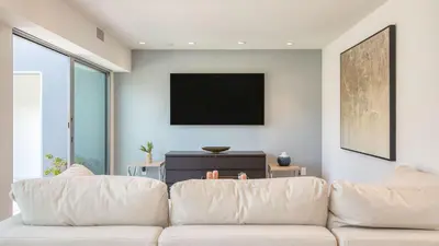 a living room with a couch and a flat screen tv at Jewel by AvantStay Panoramic Ocean Views in La Jolla in San Diego