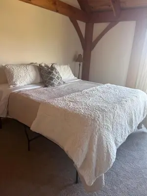 a bed with a white comforter and pillows on it at Sunset-Ridge in Alpine