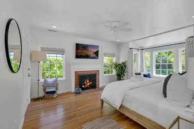 a white bedroom with a bed and a fireplace at Luxury Ocean View Retreat in San Diego
