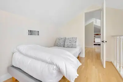 a white bedroom with a bed and a mirror at Luxury Ocean View Retreat in San Diego