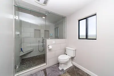 a bathroom with a toilet and a glass shower at Lakeside Hilltop Retreat with Amazing Pool and Spa in Lakeside
