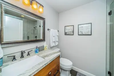 a bathroom with a sink and a toilet and a mirror at Lakeside Hilltop Retreat with Amazing Pool and Spa in Lakeside