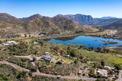 an aerial view of a house and a lake at Lakeside Hilltop Retreat with Amazing Pool and Spa in Lakeside