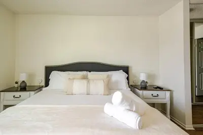 a bedroom with a white bed with white pillows at Cozy Coastal Retreat Newport Beach in Newport Beach