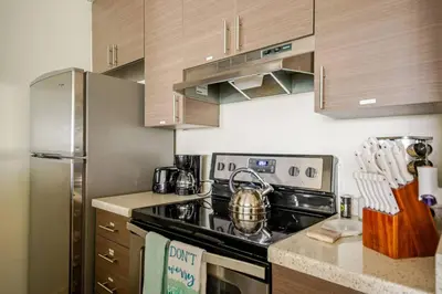 a kitchen with a stove and a stainless steel refrigerator at Cozy Coastal Retreat Newport Beach in Newport Beach