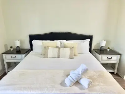 a bedroom with a white bed with two night stands at Cozy Coastal Retreat Newport Beach in Newport Beach