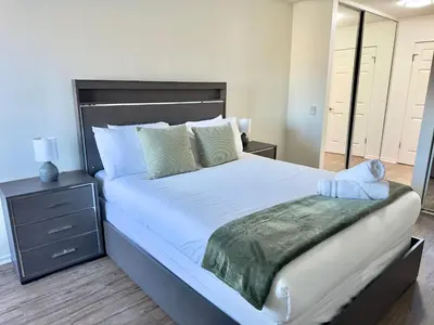 a bedroom with a large white bed with a night stand at Cozy Coastal Retreat Newport Beach in Newport Beach