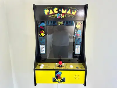 a yellow pokemon arcade game with a man in it at Cozy Coastal Retreat Newport Beach in Newport Beach