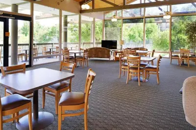 a dining room with tables and chairs and windows at Diamond Riviera Oaks Resort and Racquet Club 1BD in Ramona