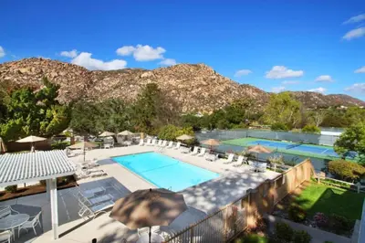 an outdoor swimming pool with chairs and umbrellas at Diamond Riviera Oaks Resort and Racquet Club 1BD in Ramona