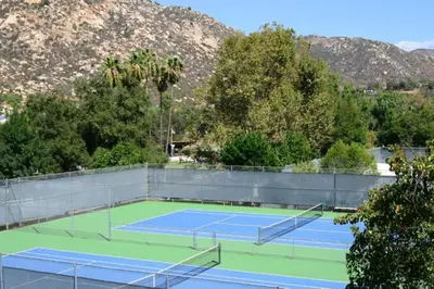 two tennis courts with mountains in the background at Diamond Riviera Oaks Resort and Racquet Club 1BD in Ramona