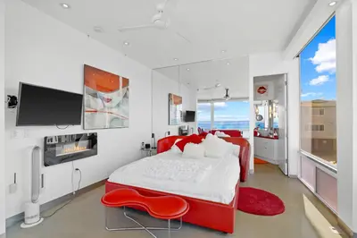 a bedroom with a red bed and a red chair at Jewel of La Jolla in San Diego